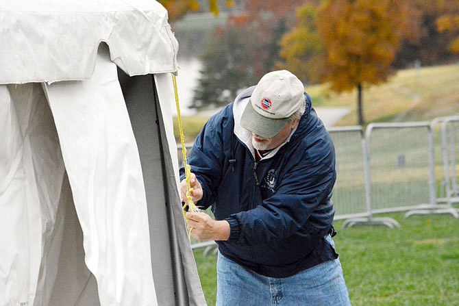 John Alewel secures a tarp Friday for the state cross country championships at Oak Hills Golf Center. This will be the 42nd year Jefferson City has hosted the race. Starting next year, it will be held in Columbia through 2023. 