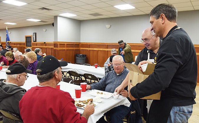 Patrick Lackman, left, Chris Luebbering, second from left, Lillian Lackman, second from right, and Lawrence Wansin, at right, enjoy a post-lunch conversation Friday at the Wardsville Lions Club, where they were treated to a meal courtesy of Mid American Bank of Wardsville.