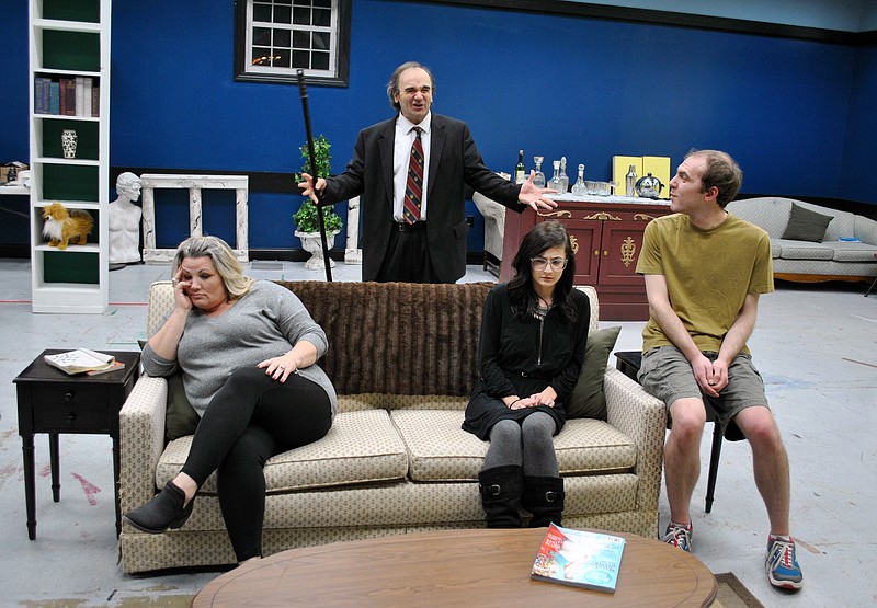 (Photo by Samantha Pogue) Detective Plotnik, played by Greg Barnes, back right, tells a story to the uniterested Perry family and their butler during rehearsals of the comedy "A Little Murder Never Hurt Anybody" Oct. 30 at The Little Theatre building.  