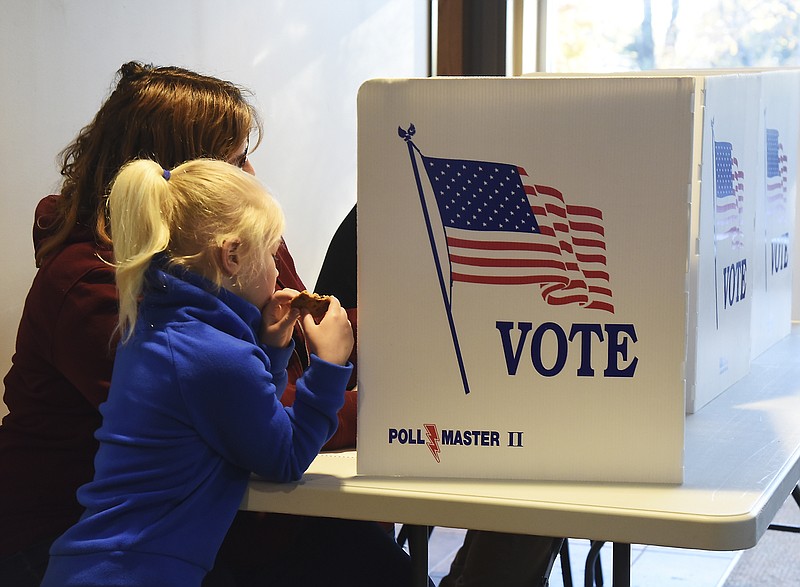 
Penn Malone, 6, stands next to and watches her mom, Anne Bloemke, on Nov. 6, 2018, as she casts her ballot at Ward 4, Precinct 1 at Our Savior's Lutheran Church in Jefferson City.