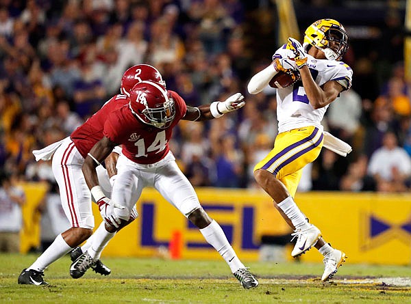LSU wide receiver Justin Jefferson (2) pulls in a reception against Alabama defensive back Deionte Thompson (14) and defensive back Patrick Surtain II (2) in the first half of Saturday's game in Baton Rouge, La.