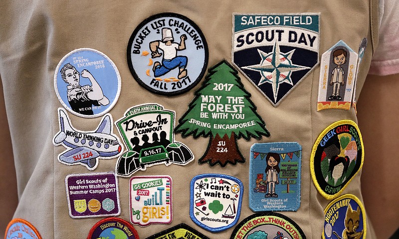 FILE - In this  June 18, 2018, file photo, patches cover the back of a Girl Scout's vest at a demonstration of some of their activities in Seattle. The Girl Scouts of the United States of America filed a trademark infringement lawsuit on Monday, Nov. 5, against the Boy Scouts of America for dropping the word "boy" from its flagship program in an effort to attract girls. (AP Photo/Elaine Thompson, File)