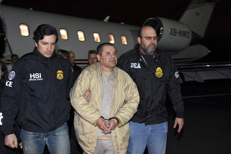 FILE - In this Jan. 19, 2017 file photo provided U.S. law enforcement, authorities escort Joaquin "El Chapo" Guzman, center, from a plane to a waiting caravan of SUVs at Long Island MacArthur Airport, in Ronkonkoma, N.Y. A jury has been picked for the U.S. trial of the Mexican drug lord.  Seven women and five men were selected Wednesday, Nov. 7, 2018, as jurors in the case against Guzman. The trial is set to begin Nov. 13 with opening statements in federal court in Brooklyn. (U.S. law enforcement via AP, File)