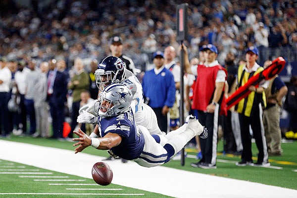Cowboys quarterback Dak Prescott reaches for the ball as Titans linebacker Wesley Woodyard defends during Monday night's game in Arlington, Texas.
