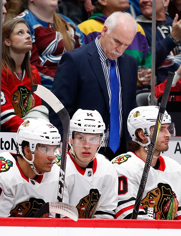 In this March 30 file photo, Blackhawks head coach Joel Quenneville looks down after his team gave up a power-play goal against the Avalanche in the second period of a game in Denver.  The Blackhawks fired the three-time Stanley Cup winning coach on Tuesday.