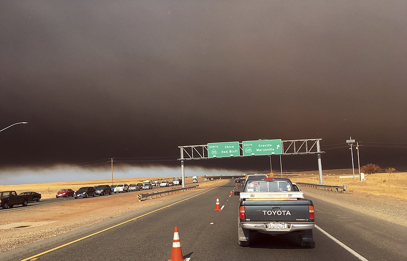 Smoke from the Camp Fire, burning in the Feather River Canyon near Paradise, Calif., darkens the sky as seen from Highway 99 near Marysville, Calif., Thursday, Nov. 8, 2018. (AP Photo/Don Thompson)