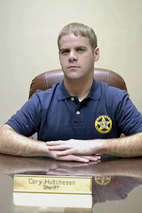 FILE - In this undated file photo, Mississippi County Sheriff Cory Hutcheson sits behind his desk at the Mississippi County Detention Center in Charleston, Mo. The family of a mentally ill Tennessee man who died after being subdued at the Mississippi County, Missouri, jail in May 2017 is seeking $20 million in a federal lawsuit. Tory Sanders died at a hospital after a scuffle with then-Sheriff Hutcheson and other officers. The lawsuit alleges that Hutcheson ignored warnings from another officer to stop putting pressure on Sanders' neck, responding, "No, I'm good." (Leonna Heuring/Sikeston Standard Democrat via AP, File)