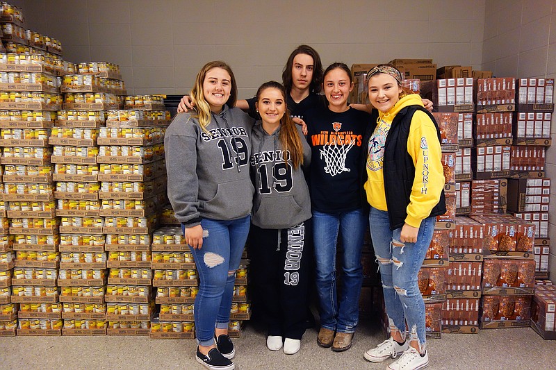 <p>Helen Wilbers/FULTON SUN</p><p>From left: Alyssa Bond, Macey Puckett, Jacob Lepper, Seara Barnard and Ashton Tate are several of the New Bloomfield High School students involved in running the school’s new food pantry. Behind them is part of a donation from Dollar General.</p>