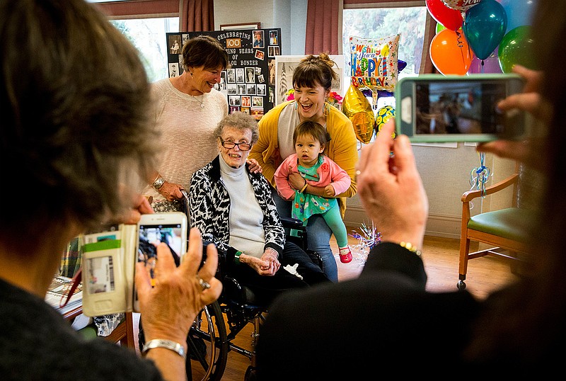 SallyLou Bonzer poses for a four-generation photo with her daughter, Lex Schmidt, left, granddaughter McKenzie Ma'aseia, a great-granddaughter Luisa Ma'aseia on the occasion of SallyLou's 100th birthday which was celebrated Wednesday, Oct. 24, 2018 by family and friends in Eugene, Ore. Bonzer, World War II veteran, landed on the beaches of Normandy, France three days after D-Day. (Andy Nelson/The Register-Guard via AP)