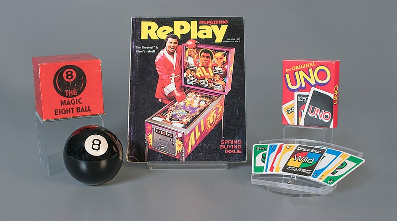 This October 2018 photo provided by The Strong museum shows the toys to be inducted into the National Toy Hall of Fame, inside the Rochester, N.Y., museum. The class of 2018 honored Thursday, Nov. 8, includes, from left, the Magic 8 Ball, pinball and the card game Uno. (Victoria Gray/The Strong via AP)