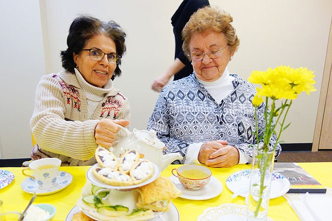 Zahra Dashtaki, left, pours tea for Beverley Gray at the Callaway County Public Library's tea party Thursday afternoon. Dashtaki said in her original country, Iran, tea is usually simmered for several minutes, sweetened and sipped from a glass cup.