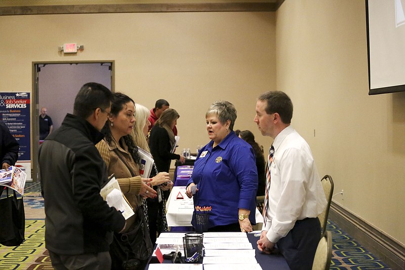 Job seekers talk to local business at the statewide career fair, Hiring Red, White and You. on Thursday at the Texarkana, Texas Convention Center.