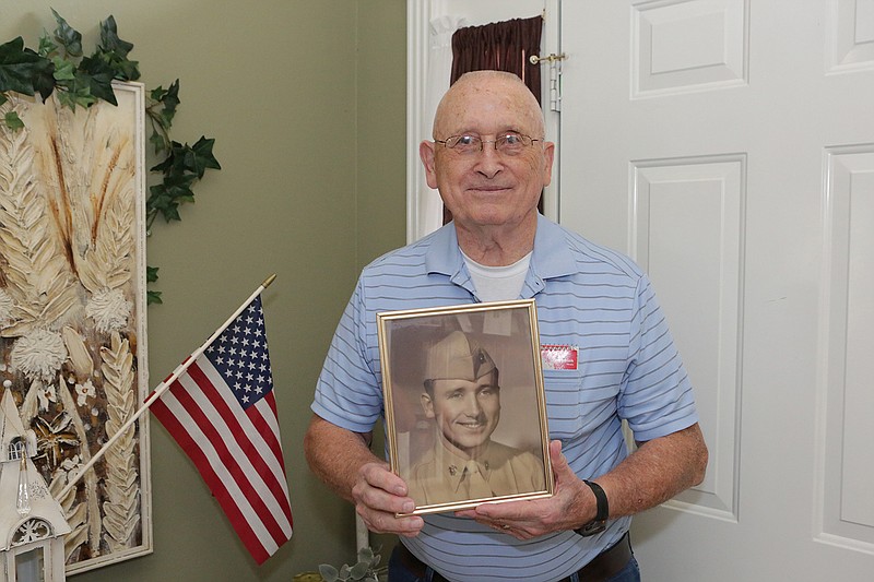 Vietnam  War veteran Max Taylor poses for a portrait in his Texarkana, Texas, home with a photo of him from his boot camp days. Taylor served in both the U.S. Marine Corps and the U.S. Army.
