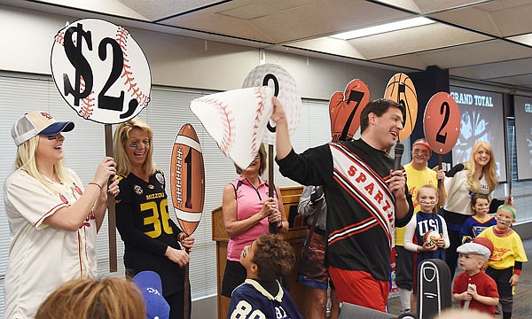 United Way Campaign co-chair Ryan Freeman, middle, reacts Thursday after revealing the total raised by this year's campaign.