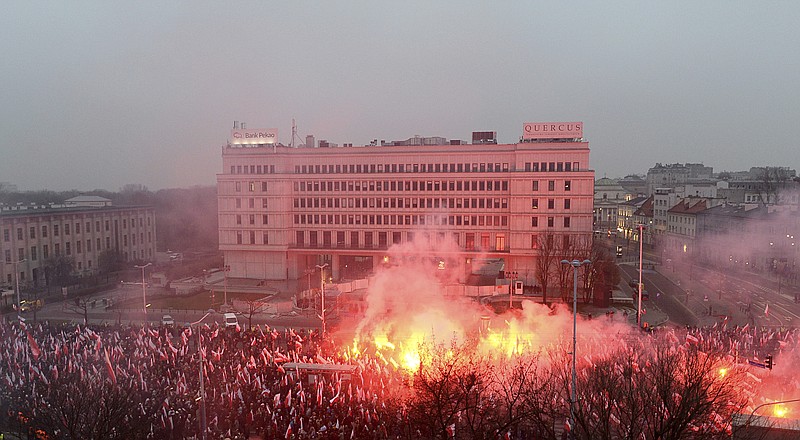 Marchers burn flares in the annual March of Independence organized by far right activists to celebrate 100 years of Poland's independence, in Warsaw, Sunday Nov. 11, 2018.  The nation of Poland regained its sovereignty at the end of World War I after being wiped off the map for more than a century. (AP Photo/Alik Keplicz)