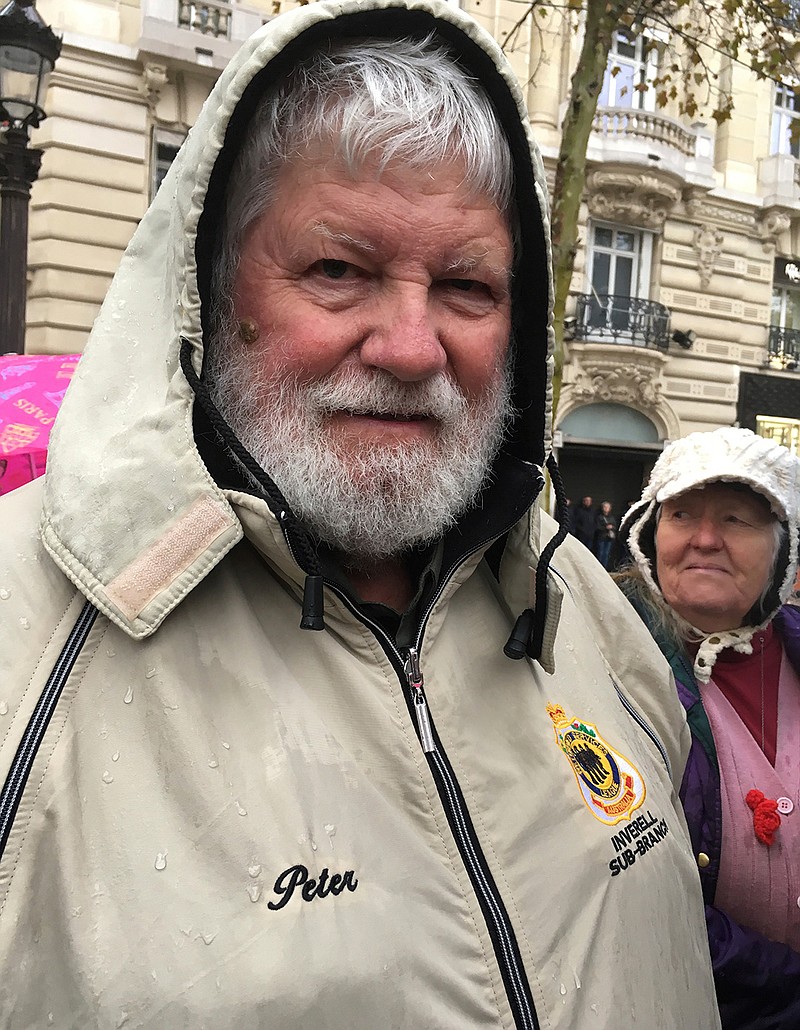 Peter Kearsey poses for a photo Sunday, Nov. 11, 2018, in Paris. Kearsey is the son of Australian soldier William Kearsey, whose face was badly damaged in World War I while fighting in Belgium with Australia's 33rd Battalion. He survived—after 28 surgeries to reconstruct his face. Peter Kearsey was among hundreds lining the rain-soaked Champs-Elysees Avenue in Paris on Sunday to honor along with world leaders those who fought in the Great War 100 years after it ended.