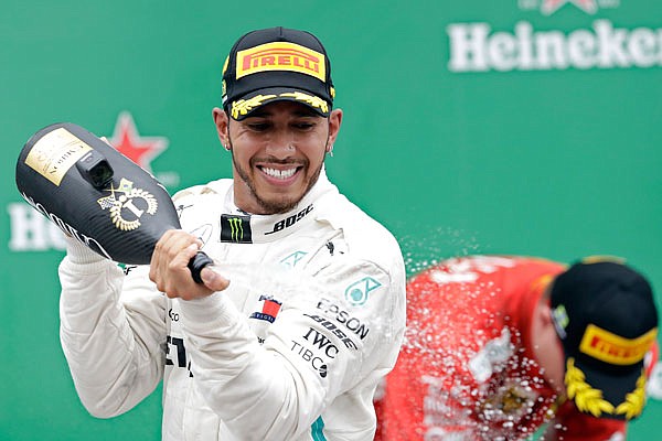 Mercedes driver Lewis Hamilton sprays champagne at the podium Sunday after winning the Brazilian Formula One Grand Prix at the Interlagos race track in Sao Paulo, Brazil.