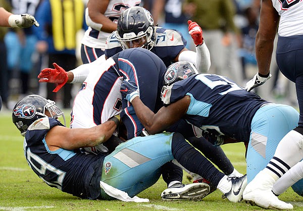 Patriots quarterback Tom Brady (center) is sacked by a group of Titans defenders in the second half of Sunday's game in Nashville, Tenn.
