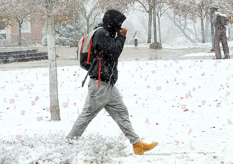 Lincoln University students walk through a heavy downpour of wet snow on the Jefferson City campus Monday, Nov. 12, 2018.