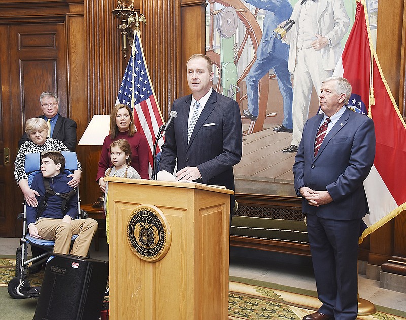 With Gov. Mike Parson, at right, looking on, Eric Schmitt is introduced as Missouri's new attorney general, who'll be taking the position vacated by Josh Hawley, who is now senator-elect Hawley. Standing with Schmitt for the announcement was his wife, Jaime, their children,  Stephen, Sophia and Olivia, and his parents, Cathy and Steve Schmitt, in background at left.