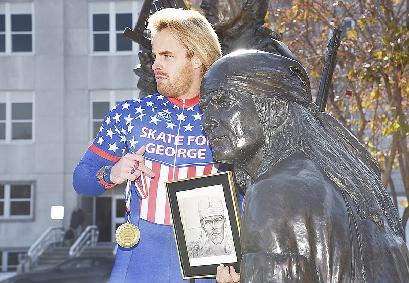 Cory Skyler Drouillard displays a medal Tuesday while standing beside a statue of his fourth great-uncle, George Drouillard. George was a French Canadian-Shawnee hunter, interpreter, scout and cartographer for Meriwether Lewis and William Clark's Corps of Discovery Expedition to chart the land acquired from France in the Louisiana Purchase.