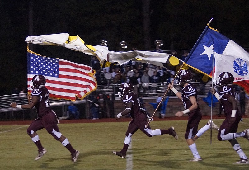 In a tribute to Veterans Day, Atlanta High football players sprint onto the field with patriotic flags to start their game with Hooks on Friday night. The leading flag-carriers are Jawan King (22), Dra Nelson (8), Carson Rich (10) and Josh Edwards (15).