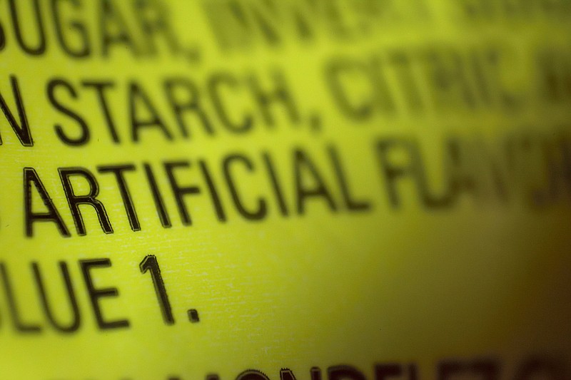 This Thursday, Nov. 8, 2018 photo shows part of an ingredient label, which lists "artificial flavoring," on a packet of candy in New York. In November 2018, the U.S. Food and Drug Administration has decided to give companies two years to purge their products of the six ingredients, described only as "artificial flavors" on packages. The words "artificial flavor" or "natural flavor" refer to any of thousands of ingredients. (AP Photo/Patrick Sison)