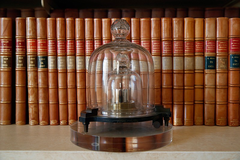 In this photo taken Wednesday, Oct. 17, 2018., a replica of the International Prototype Kilogram is pictured at the International Bureau of Weights and Measures, in Sevres, near Paris. The golf ball-sized metal cylinder at the heart of the world's system for measuring mass is heading into retirement. Gathering this week in Versailles, west of Paris, governments on Friday Nov. 16, 2018, are expected to approve a plan to instead use a scientific formula to define the exact weight of a kilo. (AP Photo/Christophe Ena)