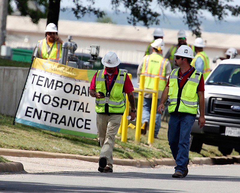  In this June 26, 2018, file photo, construction workers leave a temporary entrance to Coryell Memorial Healthcare System hospital where an explosion in a building under construction injured several people, and knocked power out for a large portion of the city in Gatesville, Texas. Investigators say an explosion that killed three people and injured 13 others at the Texas hospital earlier this year was caused by natural gas that leaked into a boiler room and an adjacent mechanical room. (Rod Aydelotte/Waco Tribune-Herald via AP, File)