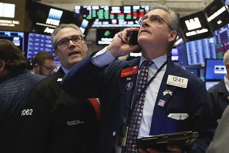 FILE- In this Nov. 8, 2018, file photo traders Eric Schumacher, left, and Richard Deviccaro work on the floor of the New York Stock Exchange. The U.S. stock market opens at 9:30 a.m. EDT on Friday, Nov. 16. (AP Photo/Richard Drew, File)