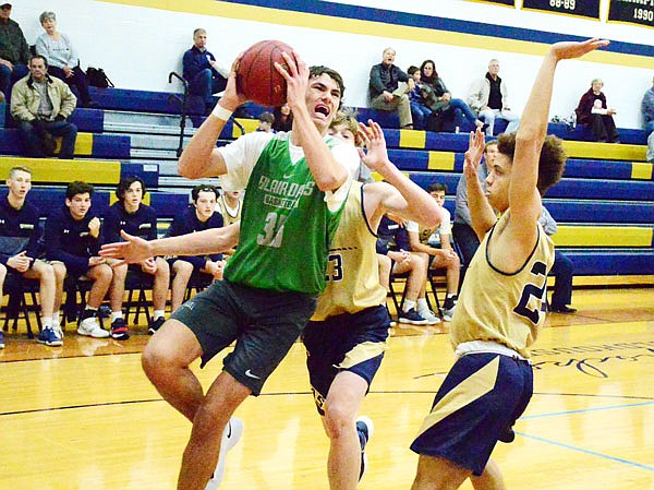 Eric Northweather of Blair Oaks tries to find an opening to the basket as he drives past Marcus Anthony (right) of Helias during Thursday night's Helias Jamboree at Rackers Fieldhouse.