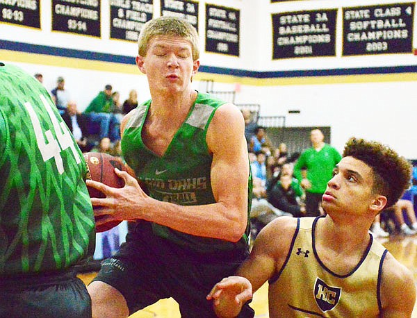 Marcus Anthony of Helias (right) battles for a rebound against Dru Rackers of Blair Oaks during Thursday night's Helias Jamboree at Rackers Fieldhouse