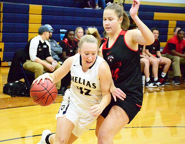 Meagan Engelbrecht of Helias drives to the lane against Jefferson City's Greta Haarmann during Thursday night's Helias Jamboree at the Helias Auxiliary Gym.