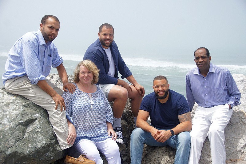 This June 2016 photo provided by Jim Jones Jr. shows, from left, Ross Jones, 21, Erin Fowler-Jones, Robert Jones, 27, and Ryan Jones, 25, and Jim Jones Jr., in Pacifica, Calif. Dozens of Peoples Temple members in Guyana survived the mass suicides and murders of more than 900 because they had slipped out of Jonestown or happened to be away Nov. 18, 1978. Those raised in the temple or who joined as teens lost the only life they knew. Jim Jr. would lose 15 immediate relatives in Jonestown, including his pregnant wife. In the aftermath, he built a new life. He remarried three decades ago, and he and his wife Erin raised three sons with two now in coaching basketball at the high school and college level. (Jim Jones Jr. via AP)