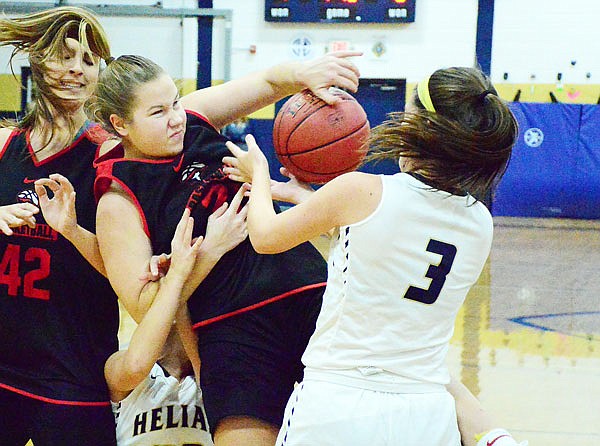 Jefferson City's Greta Haarmann battles for a loose ball against Catherine Conley of Helias during Thursday night's Helias Jamboree at the Helias Auxiliary Gym.