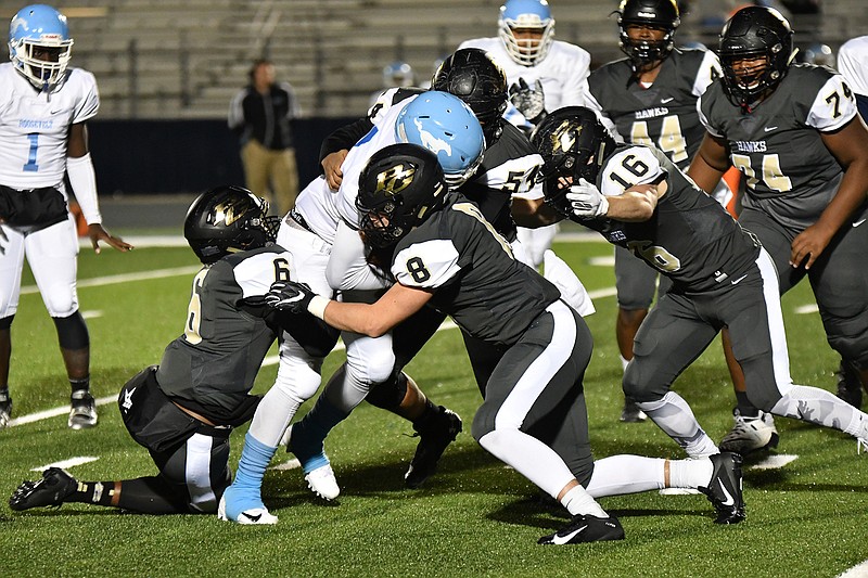 Pleasant Grove defenders Nick Martin (6), Caleb Hemphill (8), Jamie Lewis (54) and Bladen Reaves (16) gang tackle a Dallas Roosevelt ballcarrier during the Hawks' Class 4A, Division II bi-district game against the Mustangs Thursday at Paris' Wildcat Stadium. (Photo by Kevin Sutton)