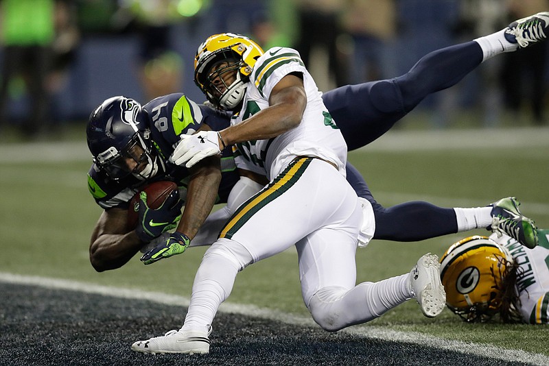 Seattle Seahawks tight end Ed Dickson, left, dives past Green Bay Packers defensive back Ibraheim Campbell, center, to score a touchdown after a reception during the second half of an NFL football game, Thursday, Nov. 15, 2018, in Seattle. (AP Photo/Stephen Brashear)