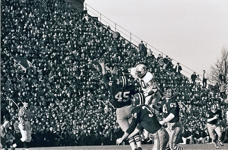 In this Nov. 23, 1968 file photo, Harvard's Tom Wynne (45), Yale's Cal Hill (3) and Harvard's Pat Conway (34) battle for a Yale pass during a college football game at Harvard Stadium in Cambridge, Mass. Sixty-five members of Harvard's 1968 football team are expected back on campus this weekend for the 50th anniversary of The Game's most memorable edition.  (AP Photo/File)
