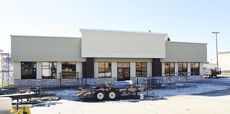 Julie Smith/News Tribune
Doug Jett, Geff Garrett and Dennis Sellars of All-Spec Metal install a coping cap on the building at 2021 Missouri Blvd. The building most recently housed Golden China restaurant and is now undergoing renovation by Stark Construction. 