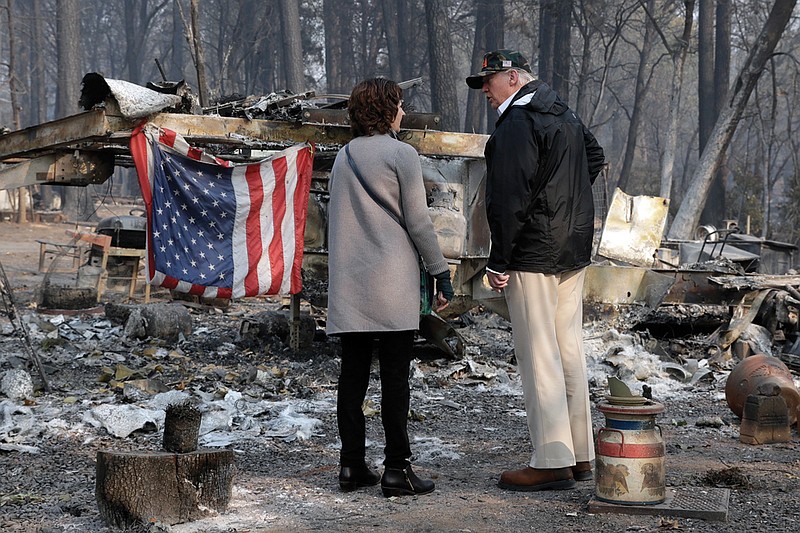 President Donald Trump talks to Mayor Jody Jones as he visits a neighborhood impacted by the wildfires, Saturday, Nov. 17, 2018, in Paradise, Calif. (AP Photo/Evan Vucci)