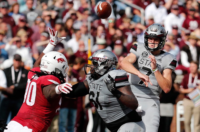 Mississippi State quarterback Nick Fitzgerald (7) passes against an on rushing Arkansas defender during the first half of an NCAA college football game in Starkville, Miss., Saturday, Nov. 17, 2018. (AP Photo/Rogelio V. Solis)