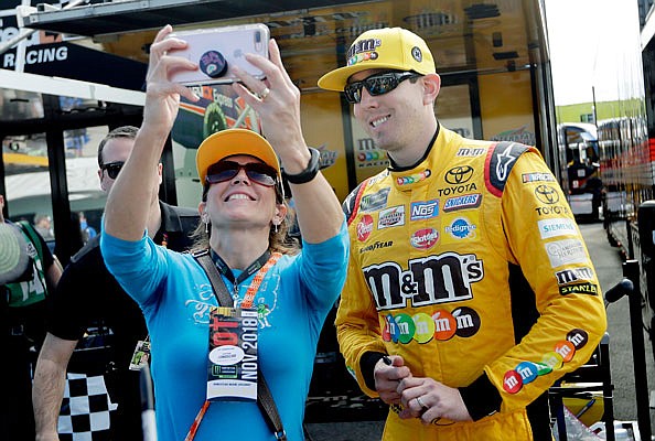 Title contender Kyle Busch takes a photo with a fan Saturday in Homestead, Fla.