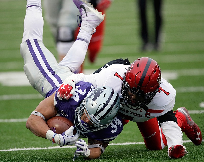 Kansas State running back Alex Barnes (34) is tackled by Texas Tech defensive back Jah'Shawn Johnson (7) during the first half of an NCAA college football game in Manhattan, Kan., Saturday, Nov. 17, 2018. (AP Photo/Orlin Wagner)
