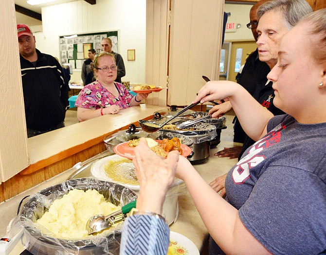 Dinner is served as patrons line up for an early Thanksgiving meal Thursday at the Holts Summit Civic Center in Holts Summit.