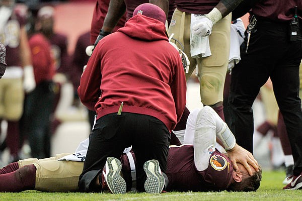 Redskins quarterback Alex Smith reacts after an injury during the second half of Sunday's game against the Texans in Landover, Md.