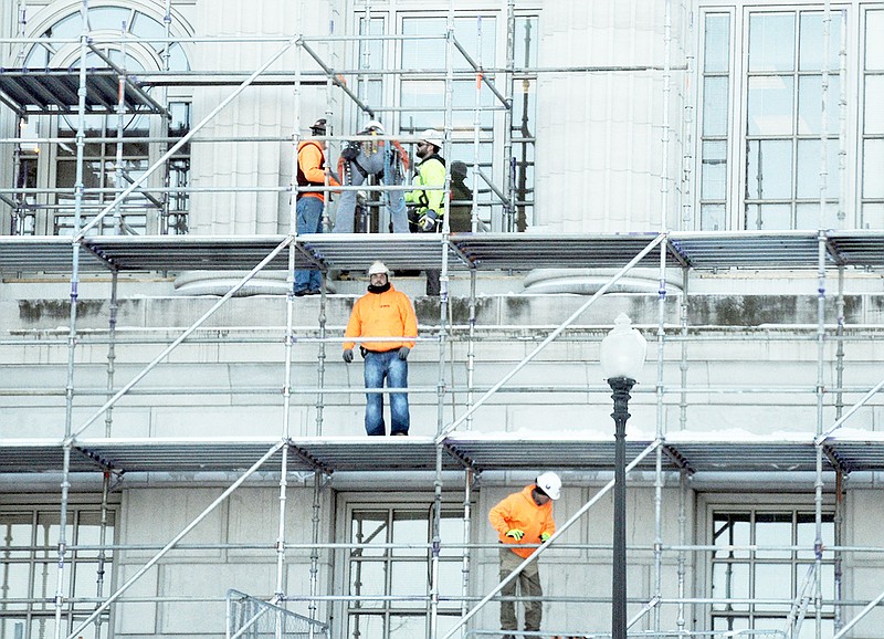 Workers at the Missouri State Capitol use the scaffolding encircling building to work Thursday.