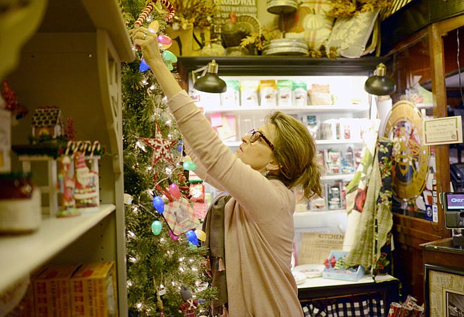 Southbank Gift Company owner Jill Bednar decorates a Christmas tree Tuesday at her High Street shop as Bednar and her team are getting ready for small business Saturday this week.