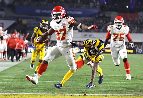 Chiefs running back Kareem Hunt scores a touchdown ahead of Rams free safety Lamarcus Joyner (20) as Chiefs offensive guard Cameron Erving (75) looks on during the first half of Monday night's game in Los Angeles.
