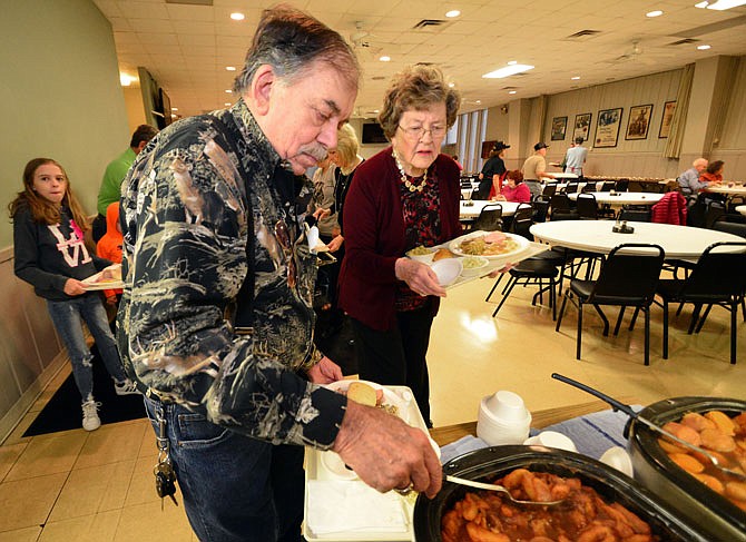 Butch Goodin loads up a family-style Thanksgiving meal Thursday at the American Legion as Lorraine Yanskey looks on. Goodin is a Vietnam veteran who served from 1965-67.