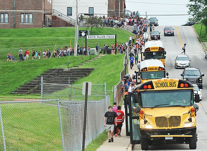 This file photo shows students boarding buses at Simonsen 9th Grade Center. Jefferson City Public Schools is considering the pros and cons of different ways to adjust its busing schedule and school start times to incorporate Capital City High School. 